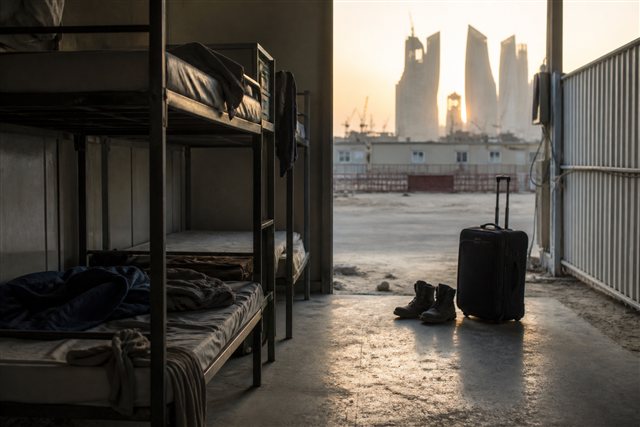 Temporary worker housing and boots at a Gulf construction site suggesting migrant labor dependence